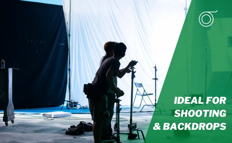 Film crew rigging a white backdrop with gaffer tape